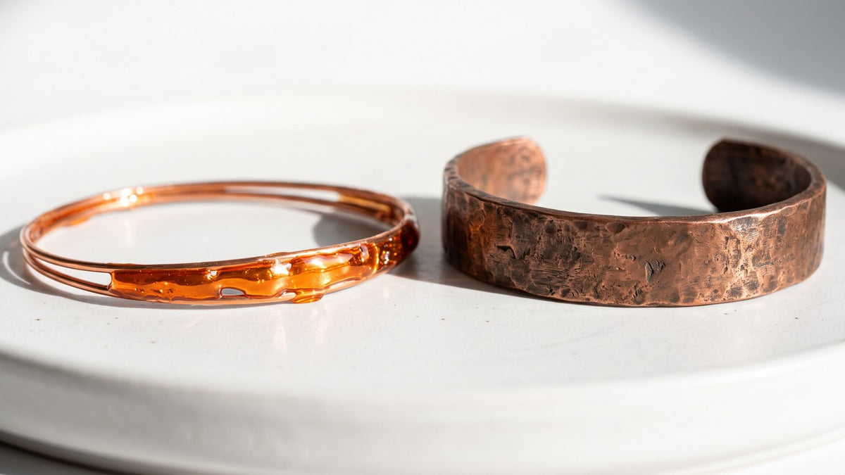 Extreme close up of a thin shiny bracelet under a hard light, the clear lacquer gleaming like glass, next to the bare ma